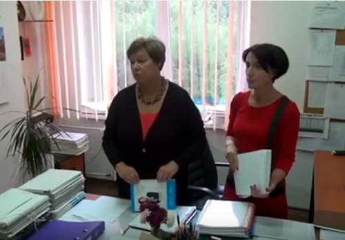 dwie stojące kobiety (Dyrektor Beata Stawicka oraz Wicedyrektor Agnieszka Przyjankowska) przy biurku